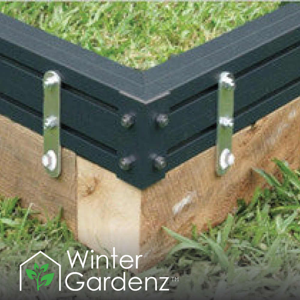 Corner detail of black metal garden bed frame flush-mounted on wooden foundation with metal brackets
